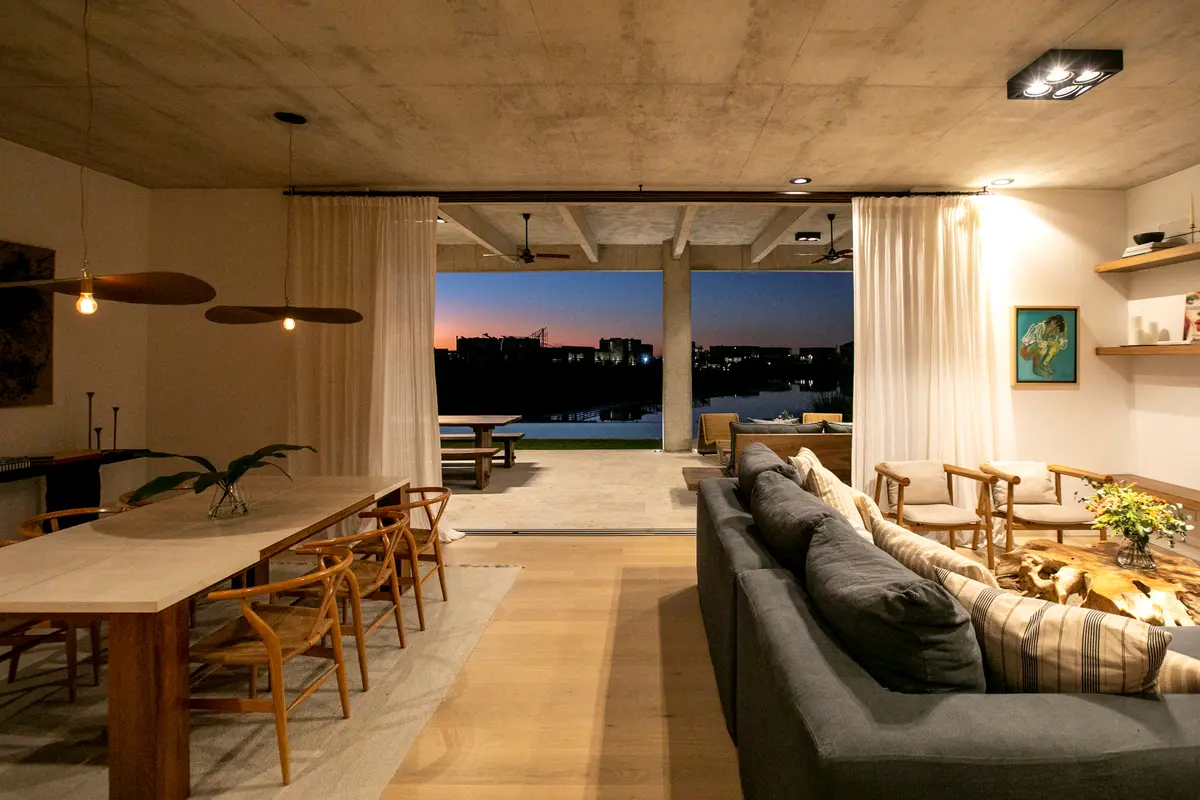 Sala de estar moderna com vista para o mar e teto de concreto — projeto Gray Rock, por BAS Y GARCIA, em Escobar